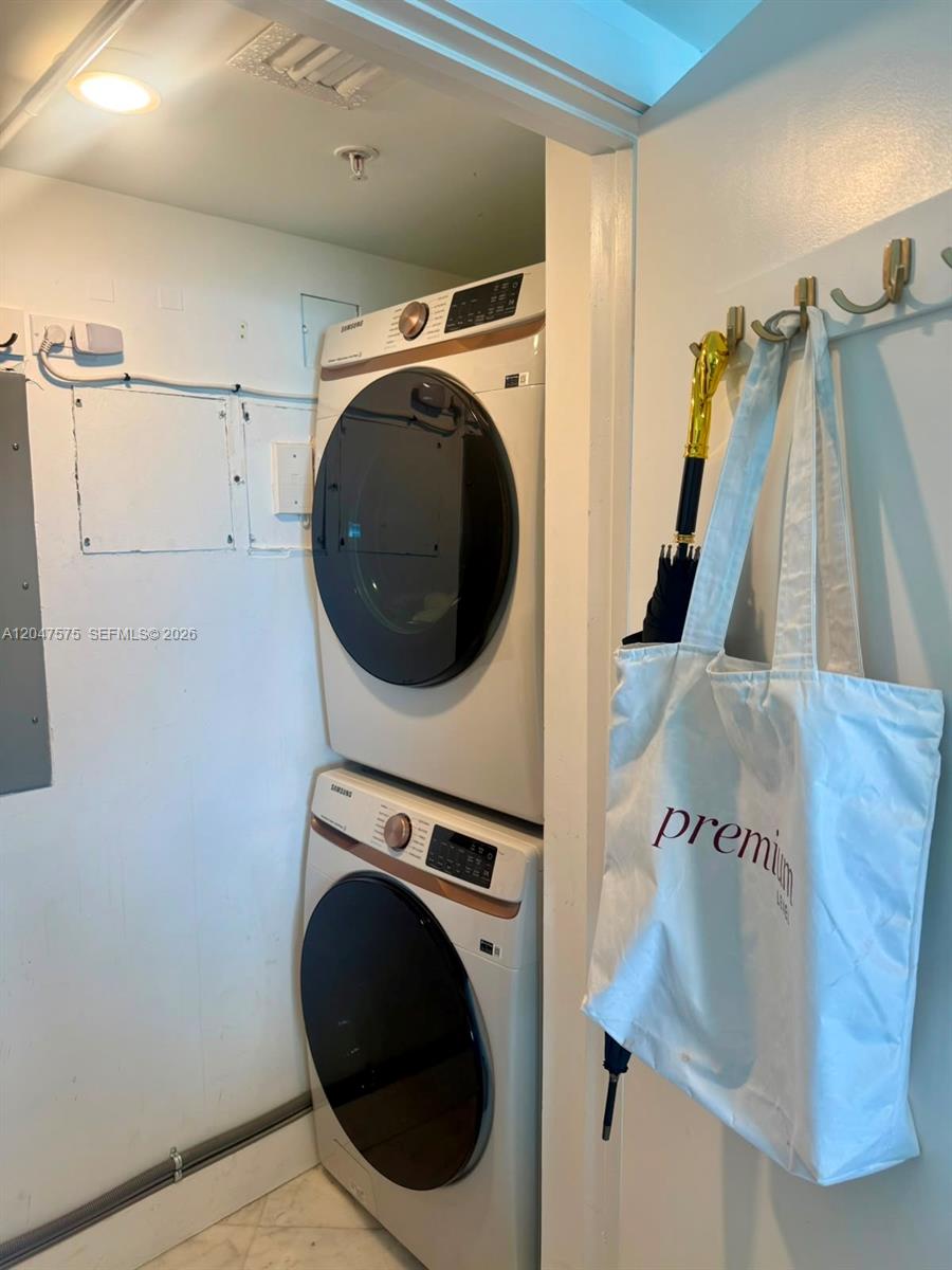 A stacked Samsung washer and dryer unit sits in a small utility closet — 9201 Collins Ave # 826, Surfside FL 33154, SURFSIDE, FL
