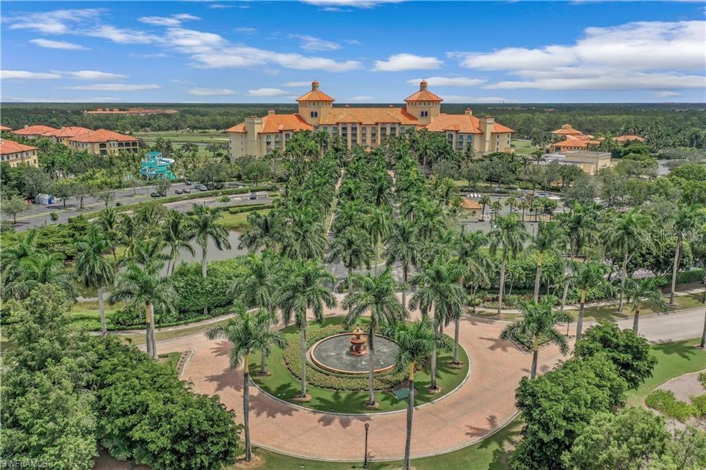 An aerial view shows a large resort hotel with a circular fountain and palm trees — 2555 MARQUESA ROYALE LANE UNIT PH 302, NAPLES, FL