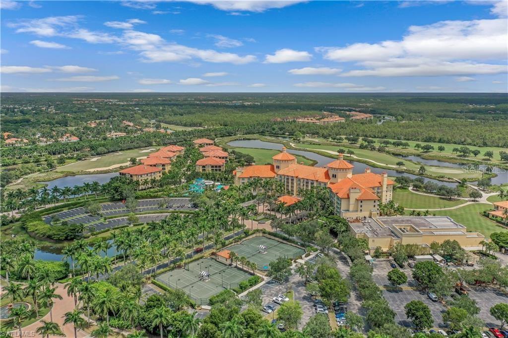 An aerial view of a resort complex featuring tennis courts, swimming pools, and a golf course — 2555 MARQUESA ROYALE LANE UNIT PH 302, NAPLES, FL