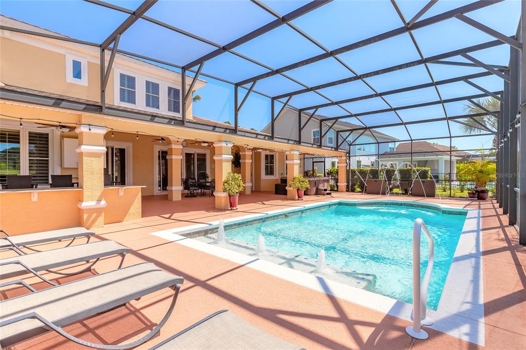 A screened-in patio features a swimming pool with fountains and several lounge chairs — 20 PROMENADE AT LIONSPAW, DAYTONA BEACH, FL