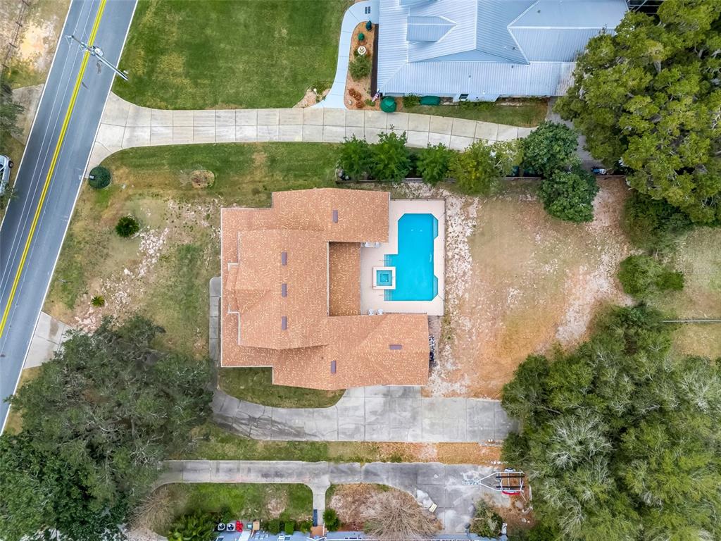 An aerial view shows a house with a shingled roof, a pool, and a driveway — 10336 LAKE LOUISA ROAD, CLERMONT, FL