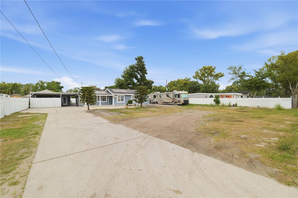 A single-story house with a large concrete driveway, a carport, and a parked RV — 1309 W ARCTIC STREET, TAMPA, FL