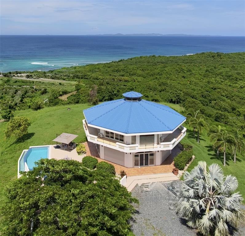 An aerial view shows a multi-story octagonal house with a blue roof and a swimming pool — 736 BRISAS DE JASMIN, VIEQUES, PR