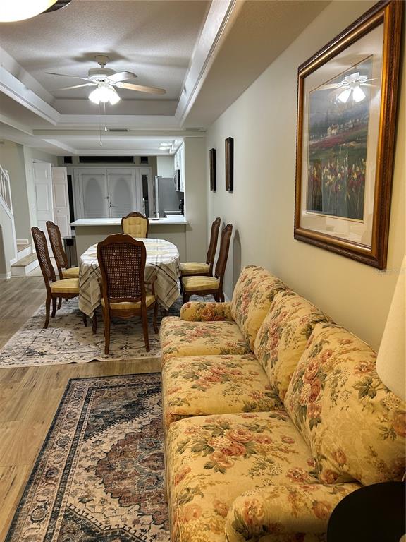 A living area with a floral sofa and dining set sits under a tray ceiling — 100 PALM HARBOR PARKWAY UNIT 29, PALM COAST, FL