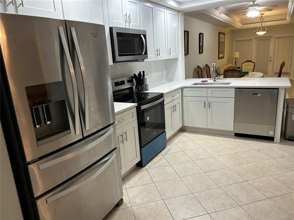 A kitchen with white cabinets, stainless steel appliances, and light tile flooring — 100 PALM HARBOR PARKWAY UNIT 29, PALM COAST, FL