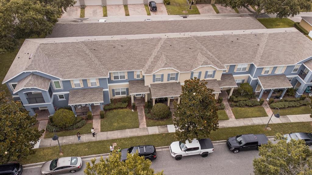 An aerial view shows a multi-unit residential building with a shingled roof and parking — 11843 DEER PATH WAY, ORLANDO, FL