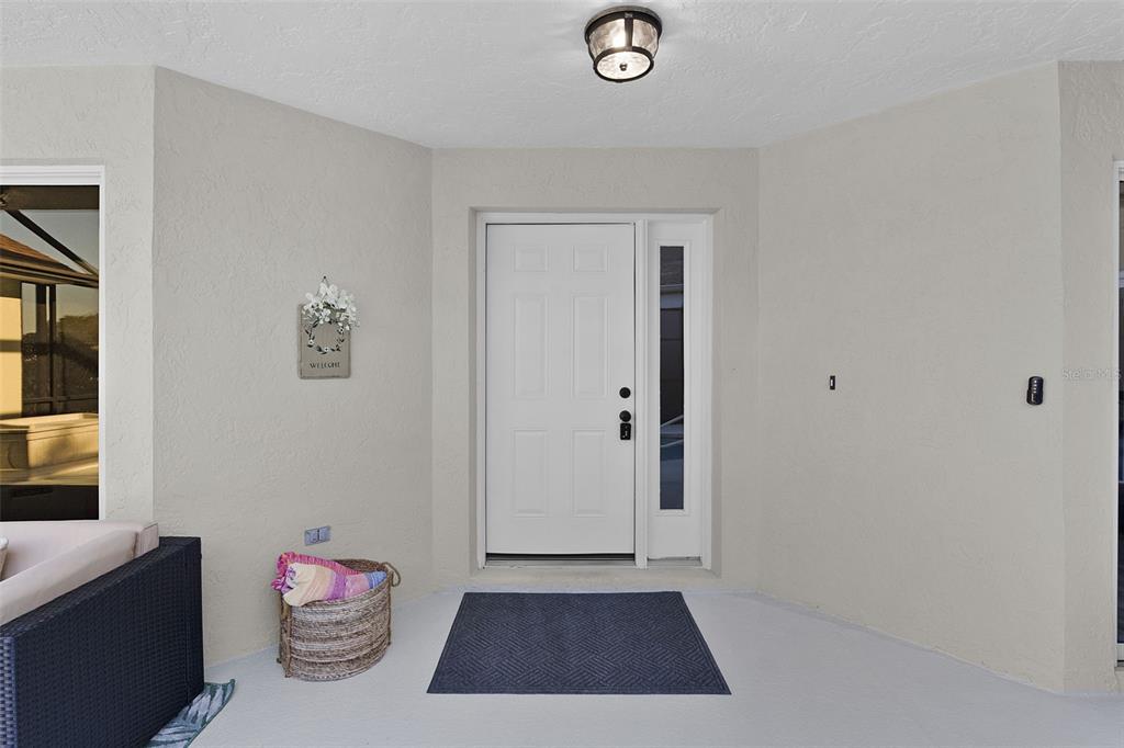 A covered entryway features a white front door with a sidelight and a welcome sign — 17824 SE 113TH TERRACE, SUMMERFIELD, FL