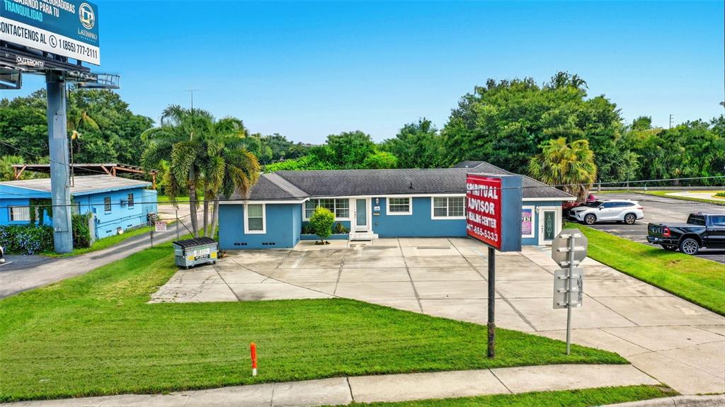 A blue single-story commercial building with a paved parking lot and a prominent roadside sign — 8027 S ORANGE AVENUE, ORLANDO, FL