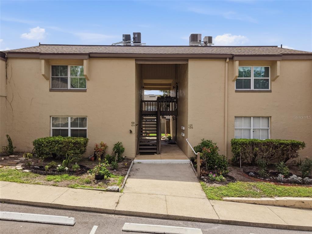 A two-story tan apartment building features a central staircase and ground-level walkways — 424 WINDMEADOWS STREET UNIT 424, ALTAMONTE SPRINGS, FL