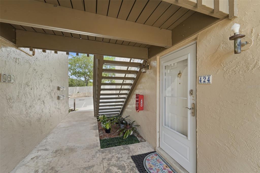 An exterior view of a ground-level apartment entrance with a staircase and a numbered door — 424 WINDMEADOWS STREET UNIT 424, ALTAMONTE SPRINGS, FL