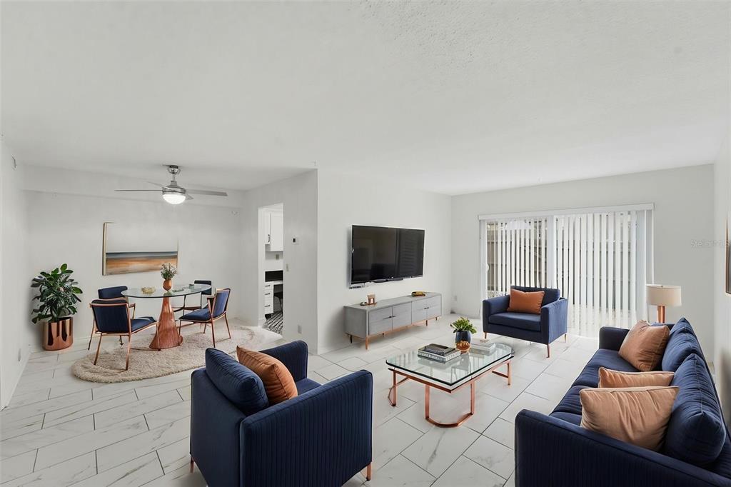 A living and dining area with white tile floors, blue furniture, and a wall-mounted television — 424 WINDMEADOWS STREET UNIT 424, ALTAMONTE SPRINGS, FL