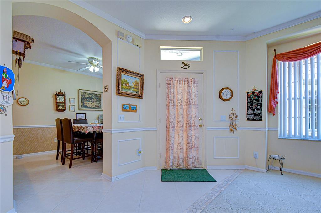 An entryway with tile flooring leads to a dining area through a wide arched opening — 6073 SANDHILL RIDGE DRIVE, LITHIA, FL