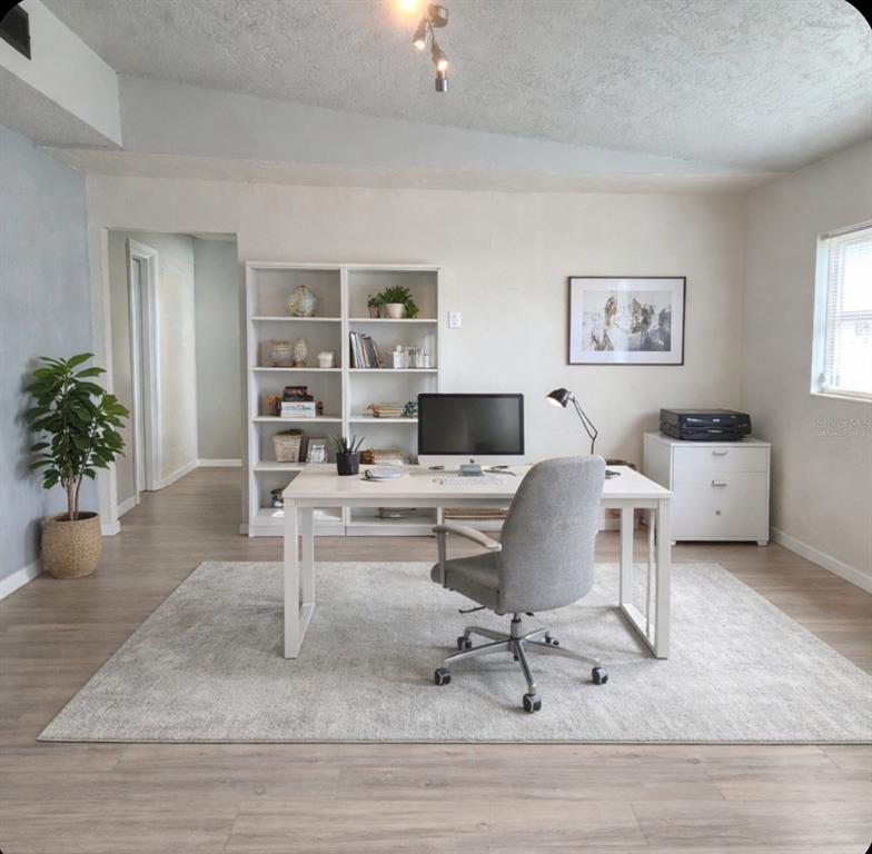 A home office features a white desk, a grey chair, and a bookshelf on wood flooring — 101 EMILY LANE, BRANDON, FL
