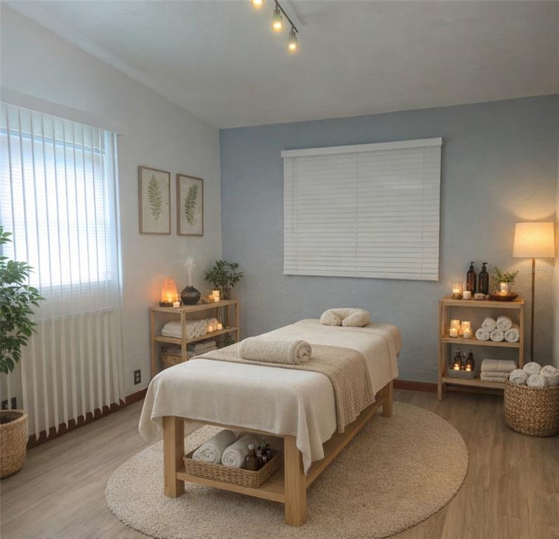 A massage therapy room features a treatment table, wooden shelving, and neutral decor — 101 EMILY LANE, BRANDON, FL