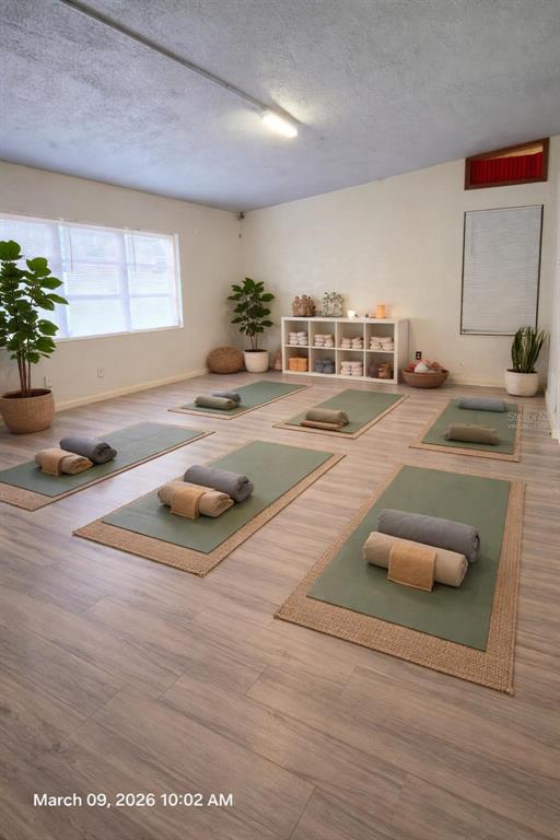 A yoga studio features light wood-look flooring, six yoga mats with props, and white walls — 101 EMILY LANE, BRANDON, FL