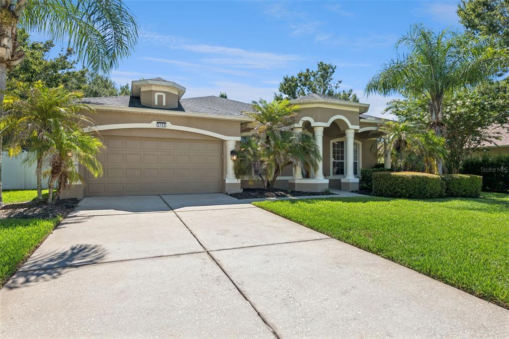 A single-story house with a tan stucco exterior, a two-car garage, and a columned entryway — 3193 TOHO COURT, KISSIMMEE, FL