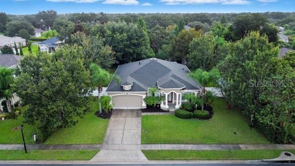 An aerial view shows a single-story house with a dark roof and a concrete driveway — 3193 TOHO COURT, KISSIMMEE, FL
