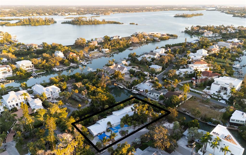 An aerial view shows a house with a metal roof and blue shade sails — 300 GARDEN LANE, SARASOTA, FL