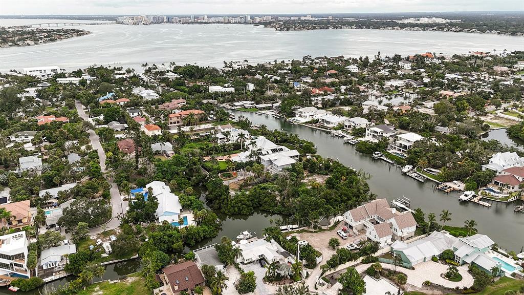 An aerial view shows waterfront homes along a canal leading to a large bay — 300 GARDEN LANE, SARASOTA, FL