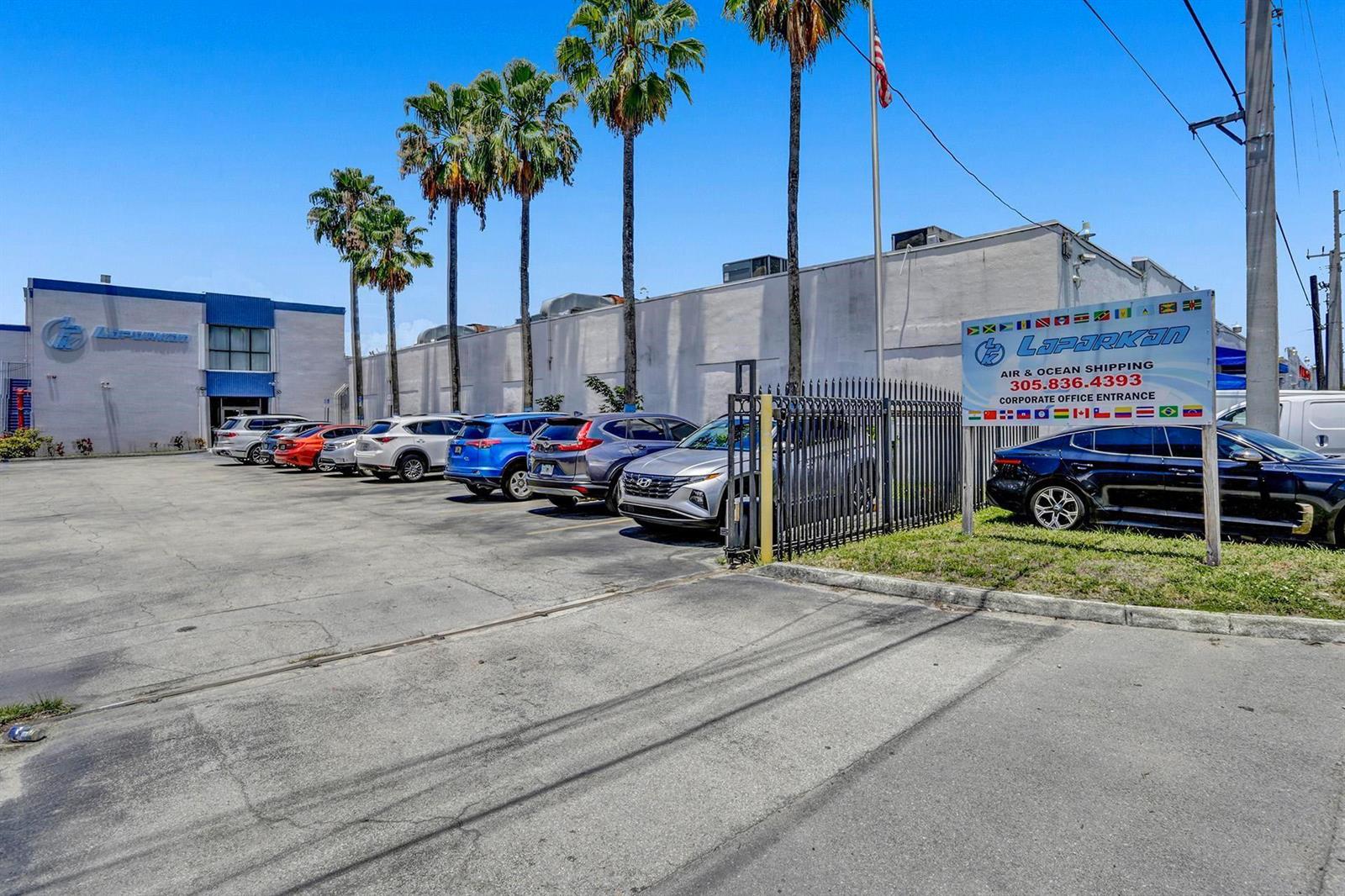 A parking lot in front of a commercial building with palm trees and signage — 3775 NW 77th Street, Miami FL 33147, MIAMI, FL