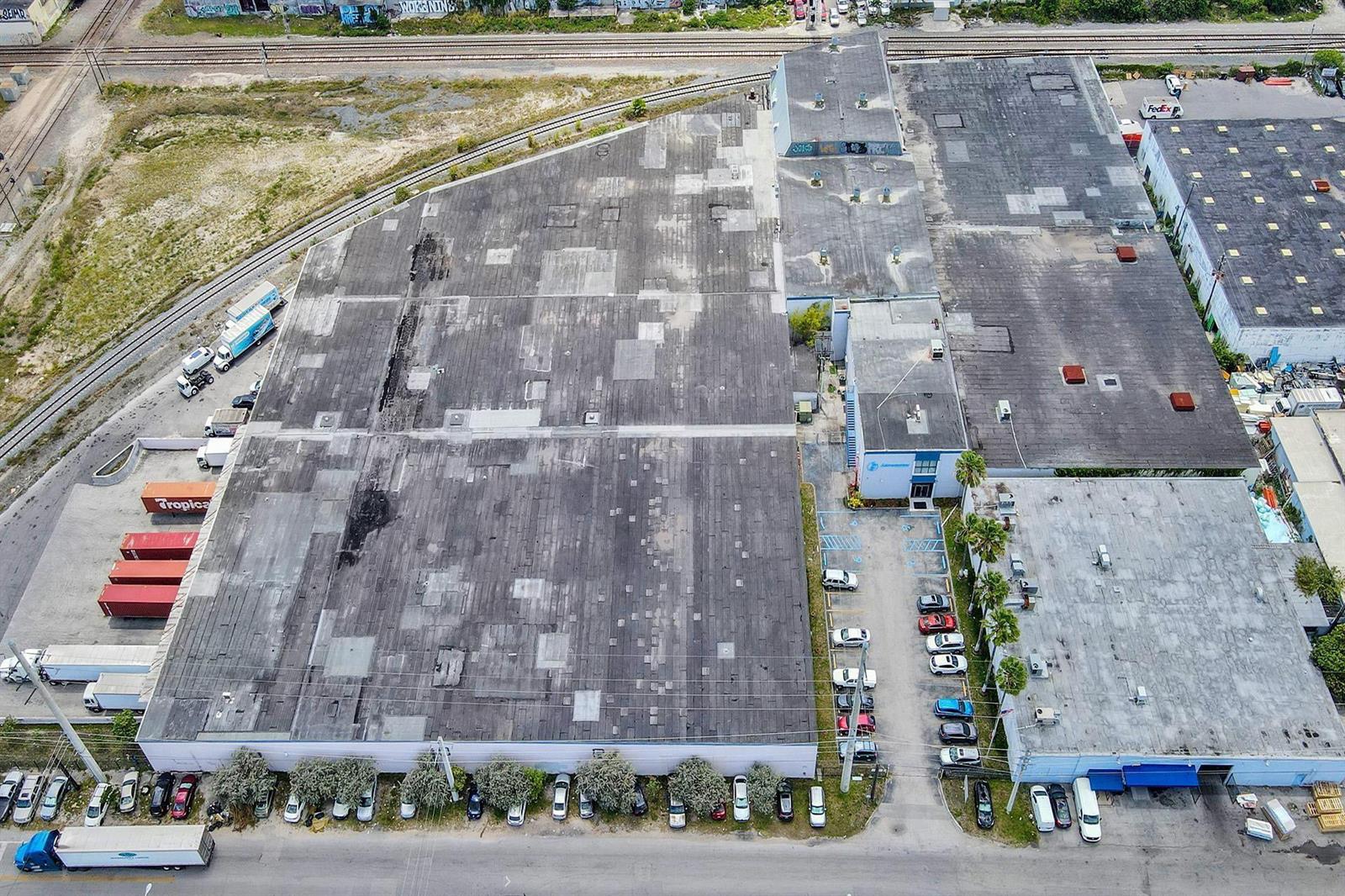 An aerial view shows a large industrial warehouse complex with a parking lot and railroad tracks — 3775 NW 77th Street, Miami FL 33147, MIAMI, FL