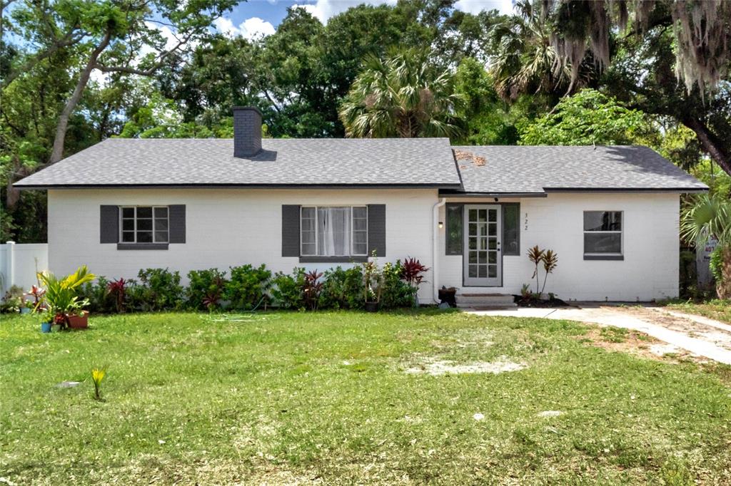 A white, single-story brick house with a gray shingled roof and dark window shutters — 322 N FRANKFORT AVENUE, DELAND, FL