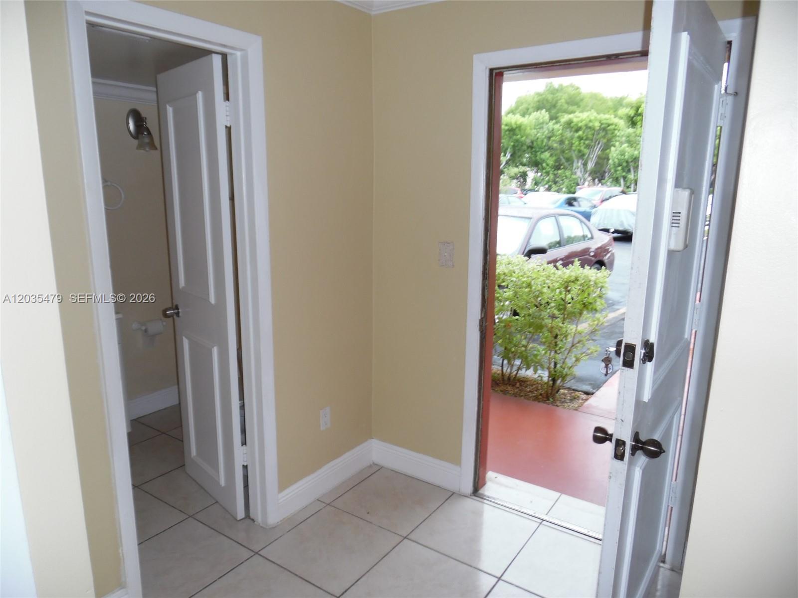A red exterior door features the number C 107 and a Life Alert sticker — 1501 NE 191st St # C107, Miami FL 33179, MIAMI, FL