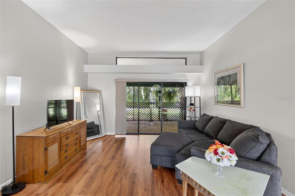 A living room features wood-look flooring, a gray sectional sofa, and a sliding glass door — 2904 PINE CLUB DRIVE, PLANT CITY, FL