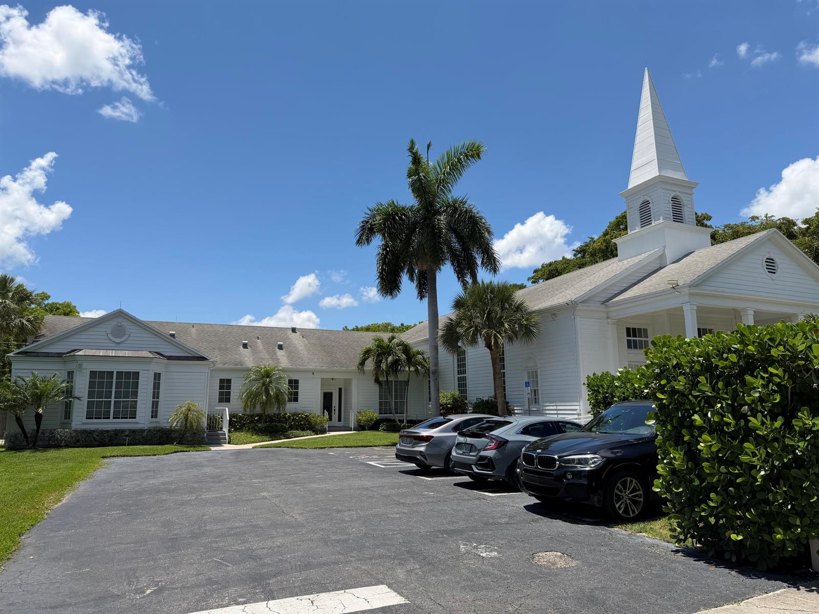 A white church building with a steeple stands behind a parking lot with three cars — 200 SE 7th Avenue, Delray Beach FL 33483, DELRAY BEACH, FL