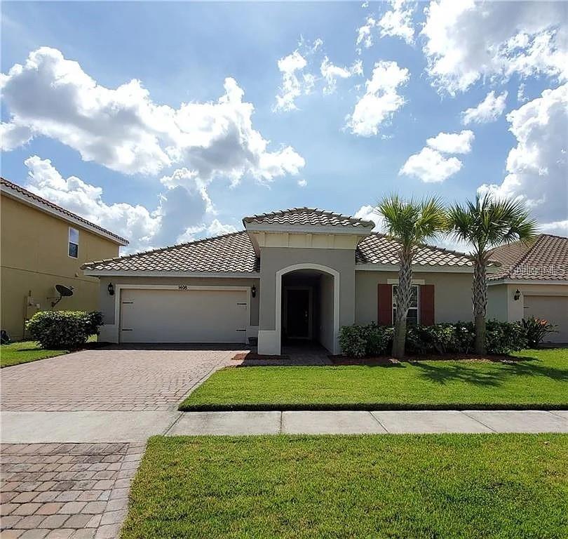 A single-story house with a tiled roof, a two-car garage, and two palm trees — 1408 LANIER POINT PLACE, KISSIMMEE, FL