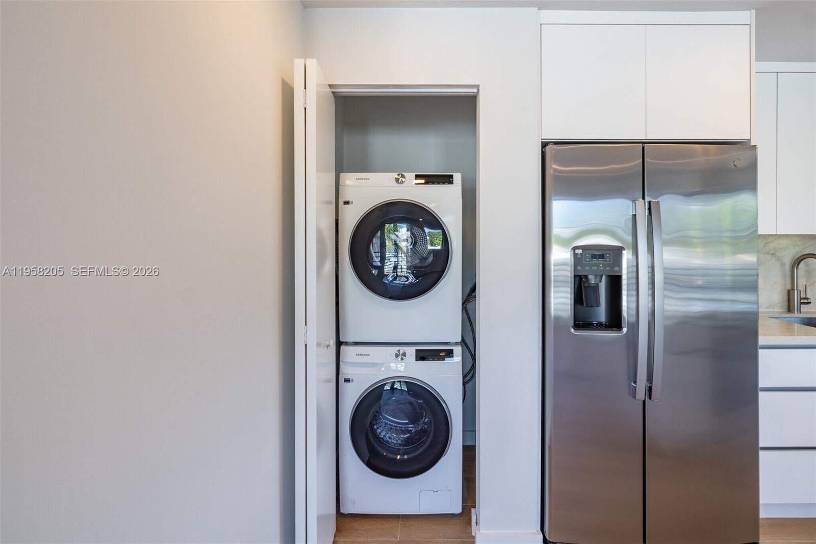 A stacked washer and dryer unit is located in a closet next to a refrigerator — 1376 SW 4th St # 401, Miami FL 33135, MIAMI, FL