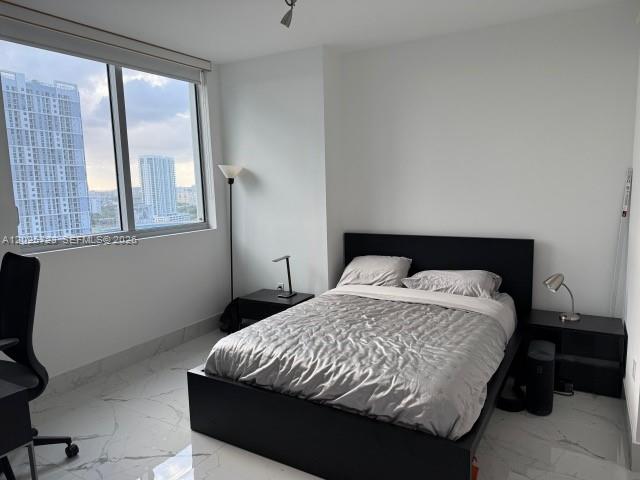 A bedroom with a black bed frame, marble-style flooring, and a view of city skyscrapers — 92 SW 3rd St # 2109, Miami FL 33130, MIAMI, FL