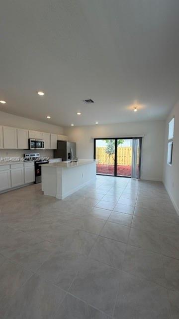 A kitchen with white cabinets, a center island, and sliding glass doors to a yard — 1302 NE 4th Ave # 0, Florida City FL 33034, FLORIDA CITY, FL