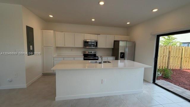 A modern kitchen features white cabinets, a central island, stainless steel appliances, and tile flooring — 1302 NE 4th Ave # 0, Florida City FL 33034, FLORIDA CITY, FL