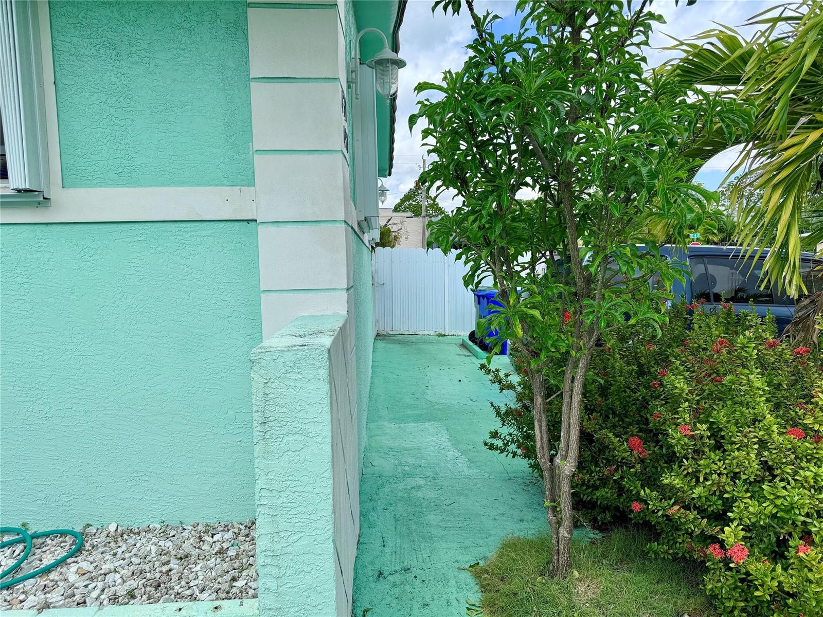 A view of a teal-painted house exterior with a matching walkway and a small tree — 430 NE 75th Street, Miami FL 33138, MIAMI, FL