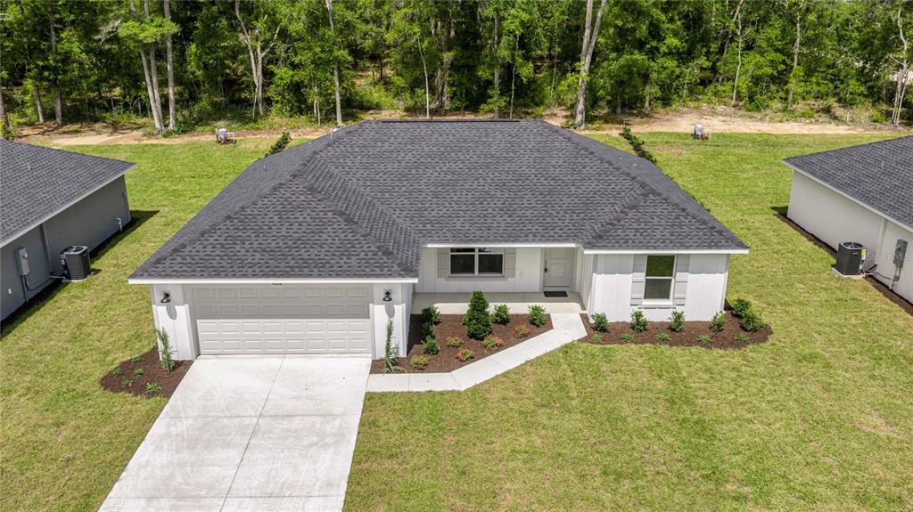 An aerial view of a single-story white house with a dark shingled roof and driveway — 4038 SW 156TH COURT, OCALA, FL