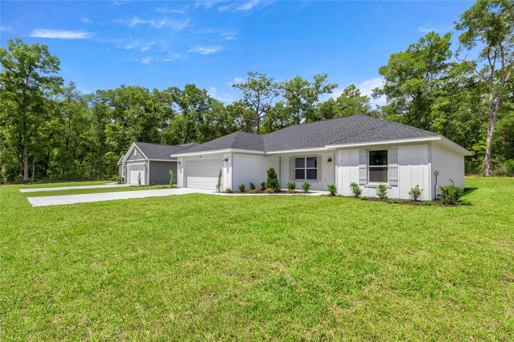 A white single-story house with a gray roof sits on a large grassy lot — 4038 SW 156TH COURT, OCALA, FL