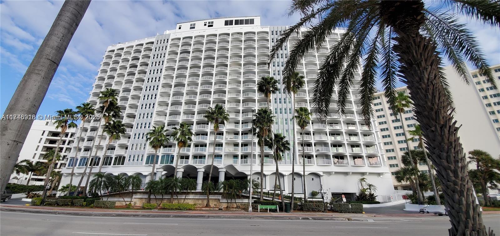 A multi-story white residential building features numerous balconies and palm trees in the foreground — 5401 Collins Ave # 628, Miami Beach FL 33140, MIAMI BEACH, FL