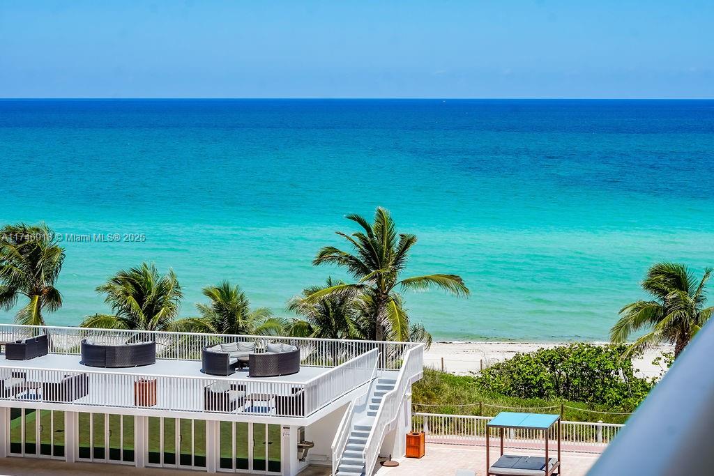 An elevated view of a beachside terrace with outdoor seating and palm trees — 5401 Collins Ave # 628, Miami Beach FL 33140, MIAMI BEACH, FL