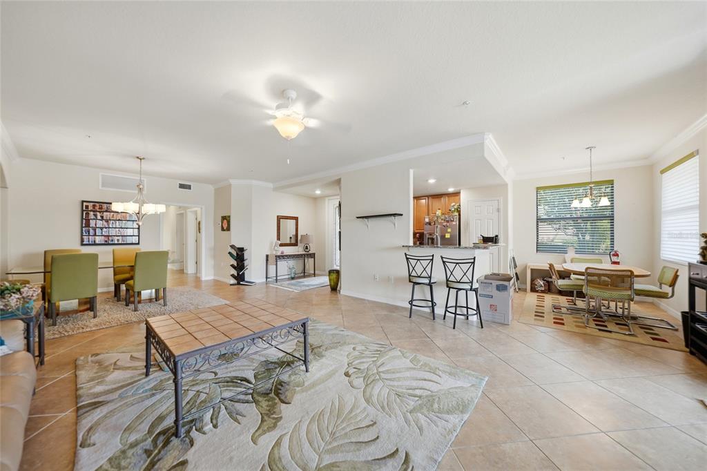 An open-concept living and dining area features tile flooring, a kitchen island, and ceiling fans — 20071 RAGAZZA CIRCLE UNIT 101, VENICE, FL