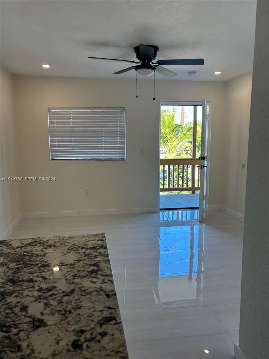 A room with white tile floors, a ceiling fan, a window, and an open door — 103365 Overseas Hwy. # B, Key Largo FL 33037, KEY LARGO, FL