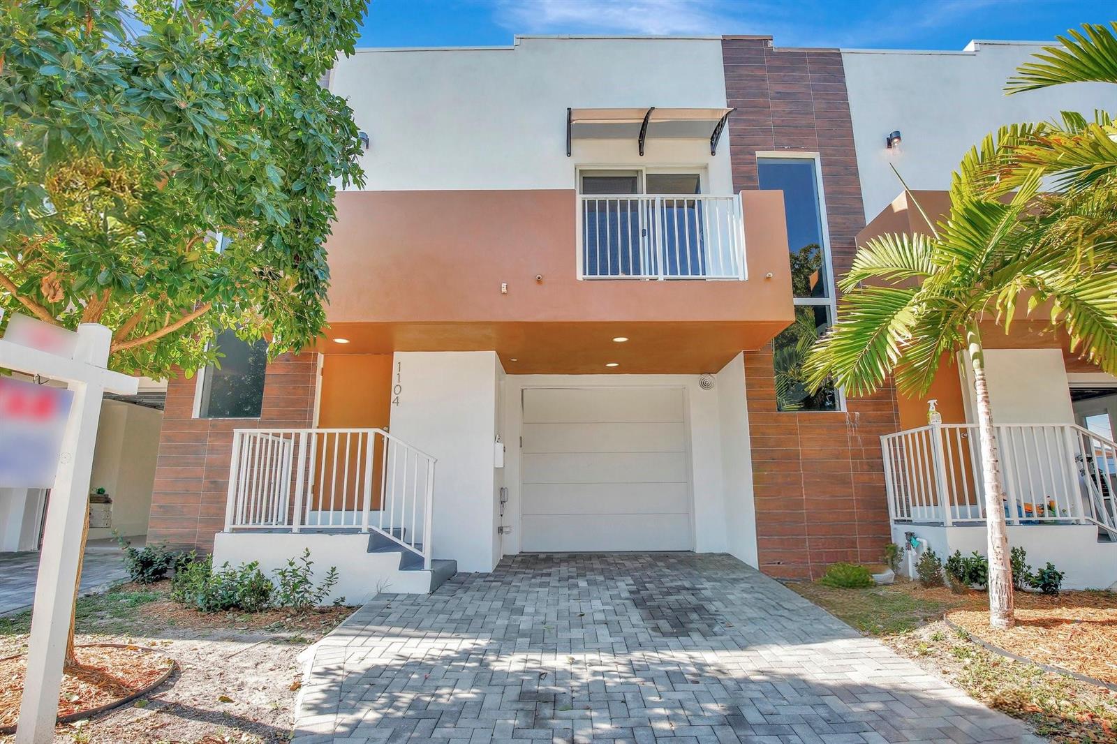 A two-story townhouse with a white garage, a balcony, and a paved driveway — 1104 S 20th Avenue, Hollywood FL 33020, HOLLYWOOD, FL