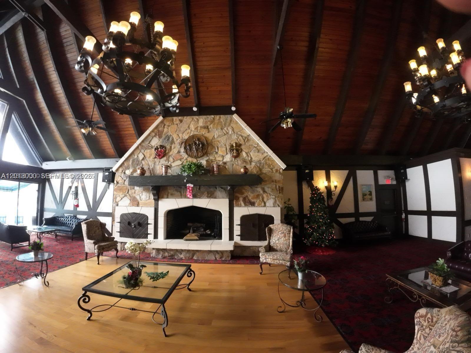 A large room features a stone fireplace, vaulted wood ceilings, and two ornate chandeliers — 3730 Inverrary Dr # 3B, Lauderhill FL 33319, LAUDERHILL, FL
