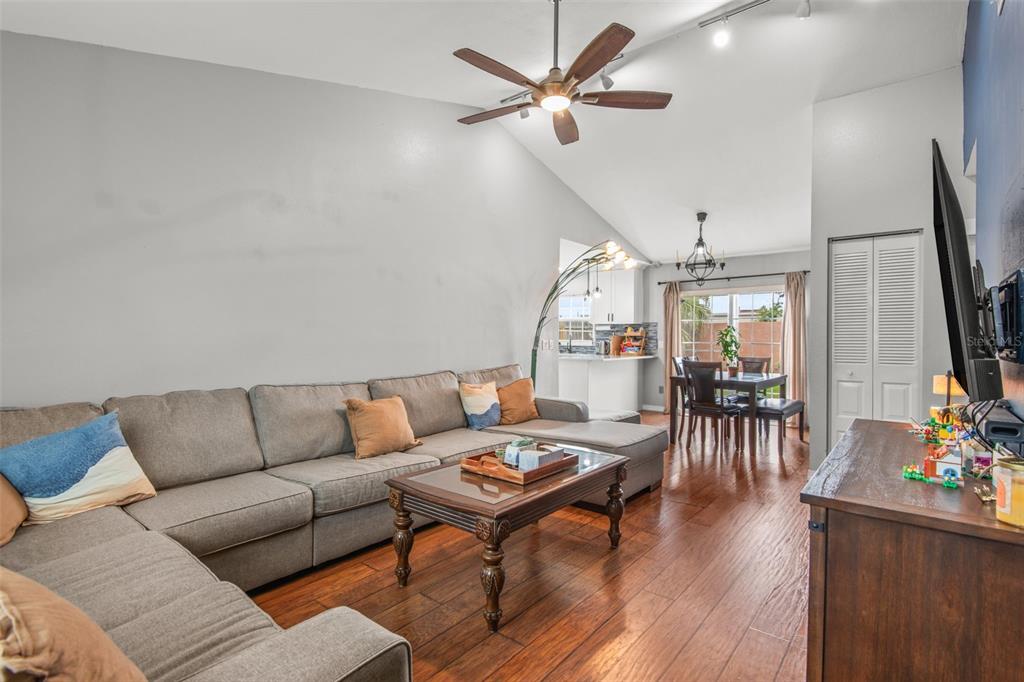 A living room with a gray sectional sofa, wood coffee table, and hardwood floors — 7591 121ST TERRACE, LARGO, FL