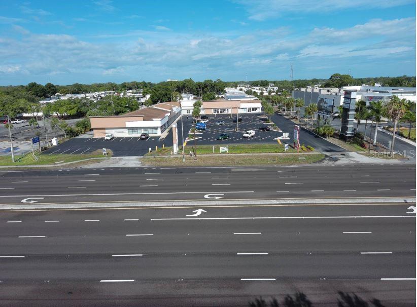 An aerial view shows a commercial building with a parking lot next to a highway — 39930 US HIGHWAY 19 N UNIT 39930, TARPON SPRINGS, FL