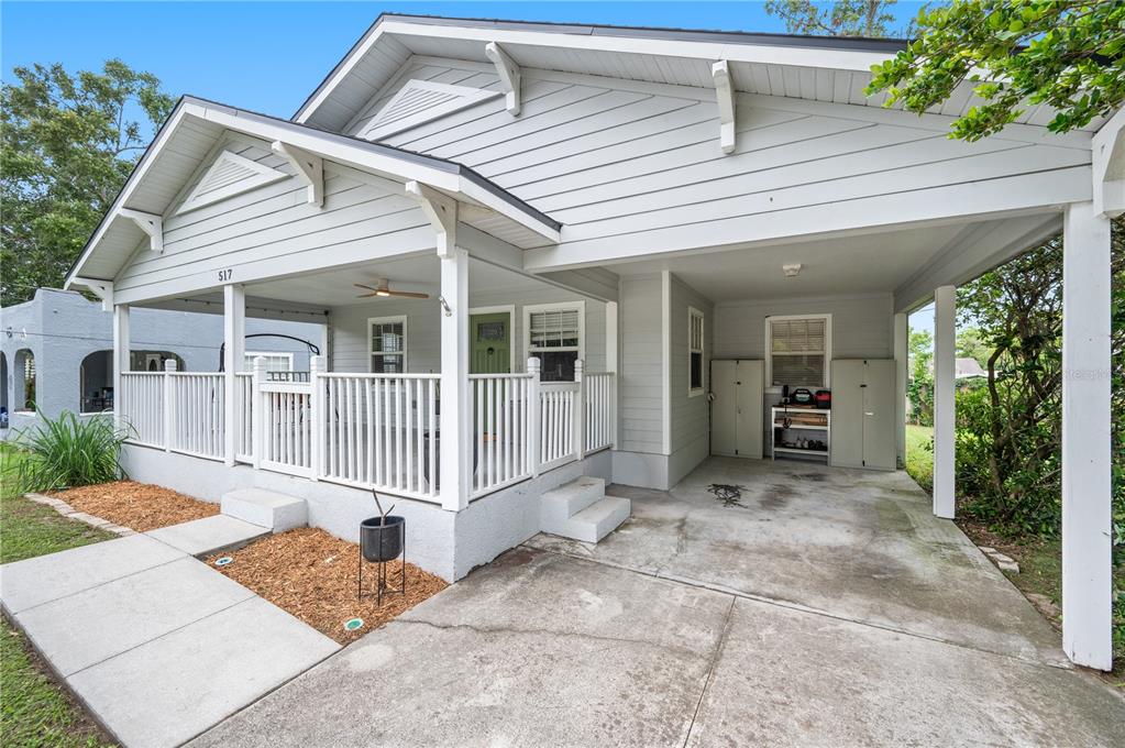 A light gray house features a covered front porch, a white railing, and a concrete carport — 517 W PATTERSON STREET, LAKELAND, FL