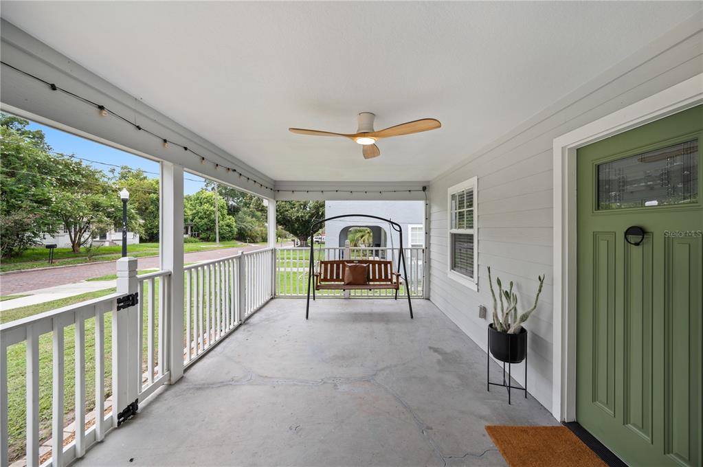 A covered front porch features a concrete floor, a porch swing, and a green door — 517 W PATTERSON STREET, LAKELAND, FL
