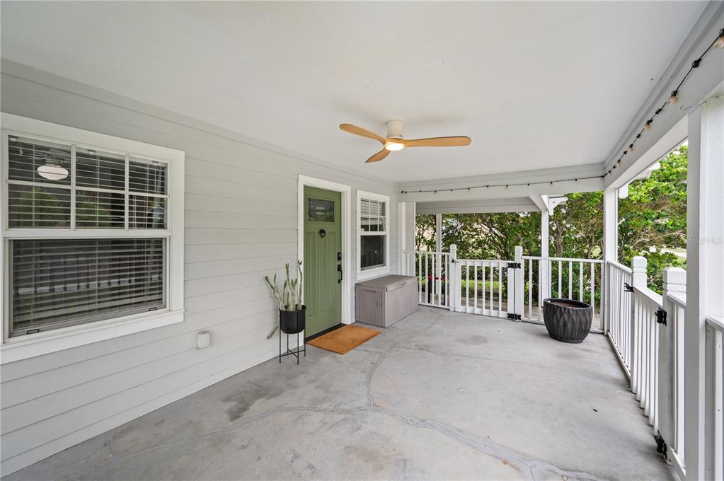A covered front porch features light gray siding, a green door, and a ceiling fan — 517 W PATTERSON STREET, LAKELAND, FL