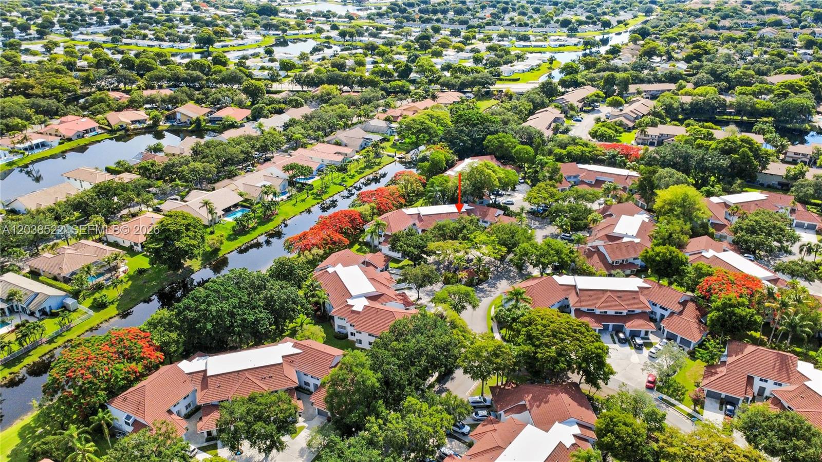 An aerial view shows a residential complex with red-tiled roofs surrounded by trees and canals — 9237 NW 9th Pl # 9257, Plantation FL 33324, PLANTATION, FL