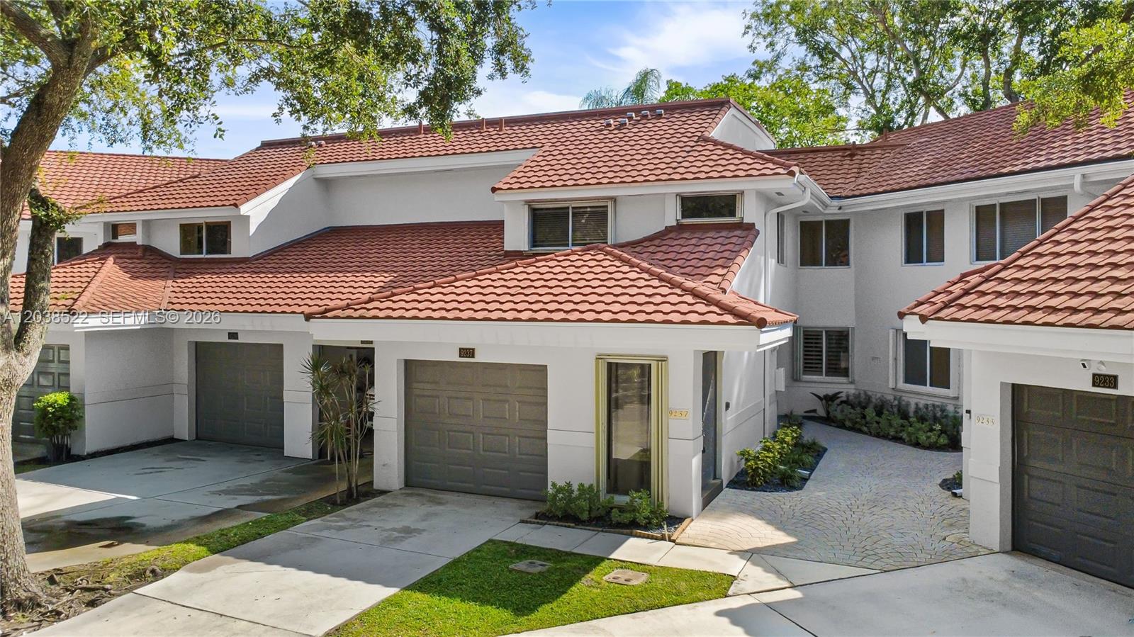 A multi-unit residential building with white stucco walls, gray garage doors, and red tile roofs — 9237 NW 9th Pl # 9257, Plantation FL 33324, PLANTATION, FL